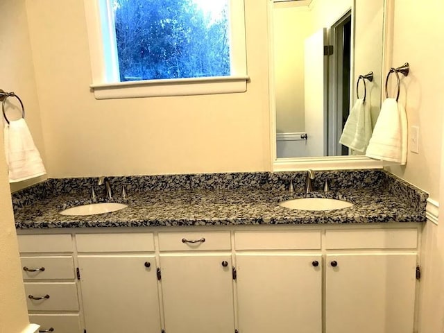 full bathroom with double vanity and a sink