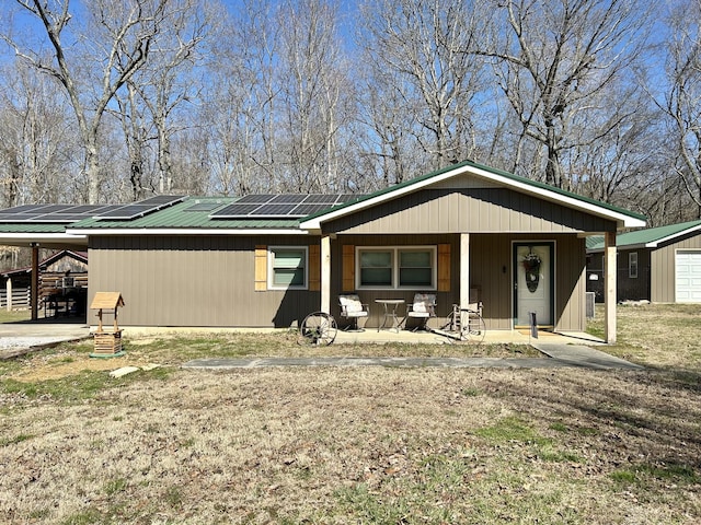 view of front of property with roof mounted solar panels and metal roof