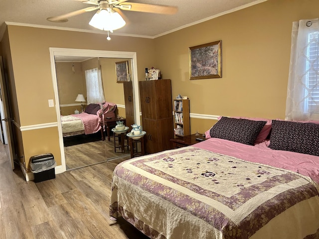 bedroom featuring a closet, ornamental molding, ceiling fan, and wood finished floors