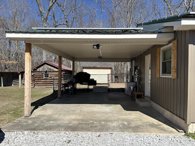 view of vehicle parking featuring an attached carport, entry steps, gravel driveway, and fence