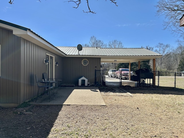 view of parking / parking lot featuring a gate, an attached carport, and fence