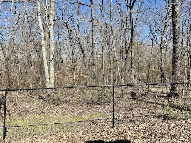 view of yard featuring fence and a wooded view