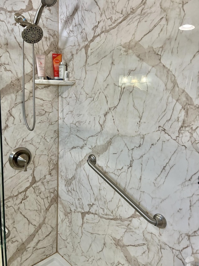 bathroom featuring a marble finish shower