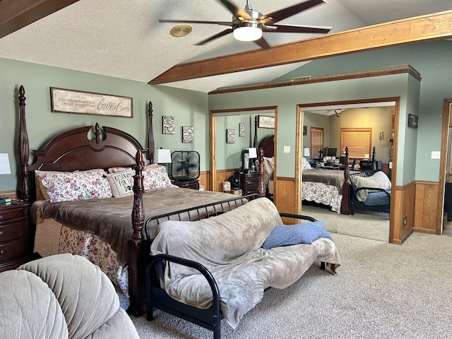 bedroom featuring lofted ceiling with beams, a textured ceiling, a closet, wood walls, and wainscoting