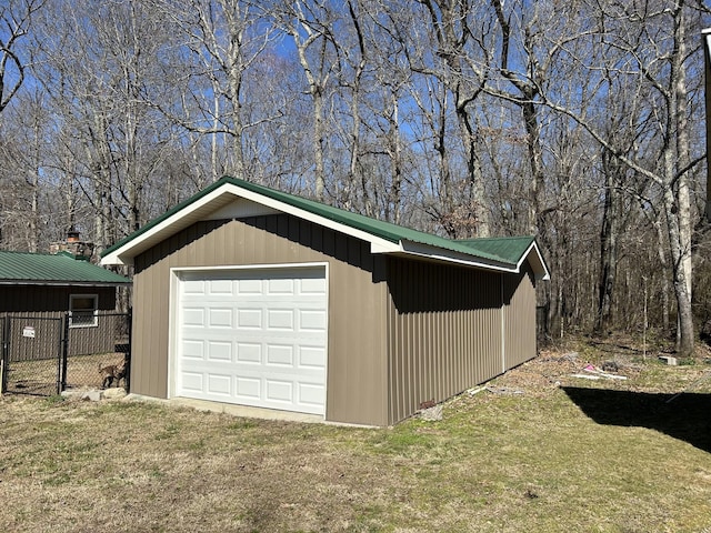 detached garage featuring driveway and fence