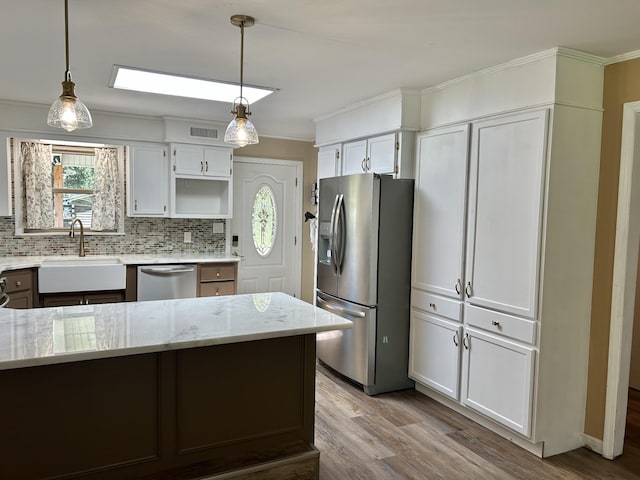 403 Bryan Blvd, Manchester, TN 37355 - kitchen with stainless steel appliances, a sink, light stone counters, wood finished floors, and crown molding