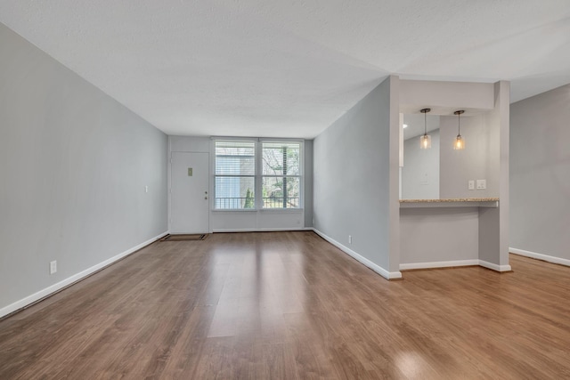 unfurnished room with baseboards and wood finished floors