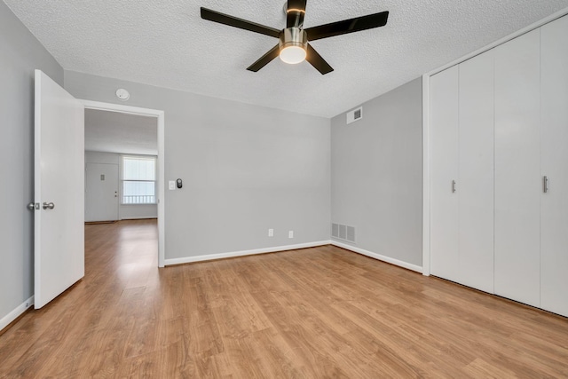 unfurnished bedroom featuring light wood-style flooring, visible vents, and a textured ceiling