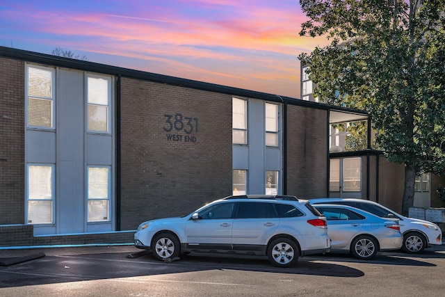 property at dusk featuring uncovered parking