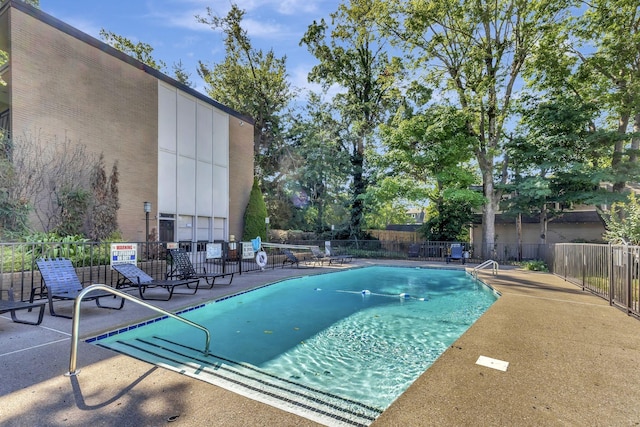 pool with a patio and fence