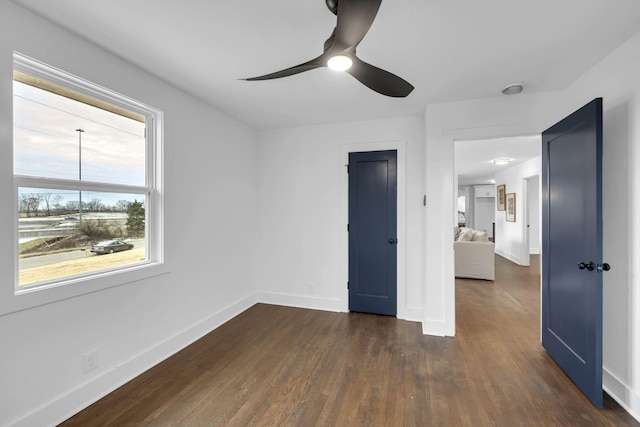 unfurnished bedroom with ceiling fan, baseboards, and dark wood finished floors