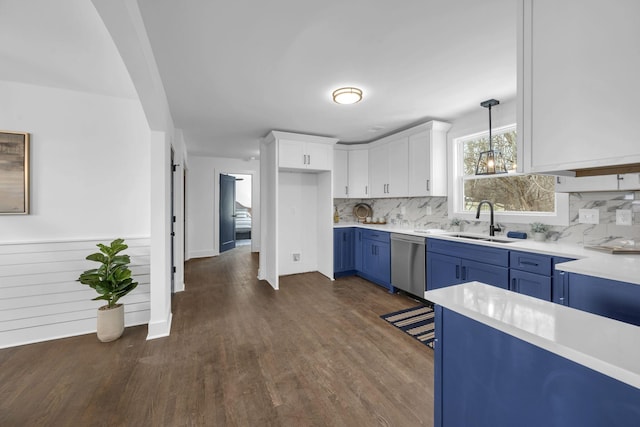 kitchen featuring white cabinets, dishwasher, decorative light fixtures, light countertops, and a sink