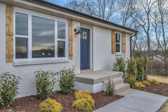 doorway to property with brick siding