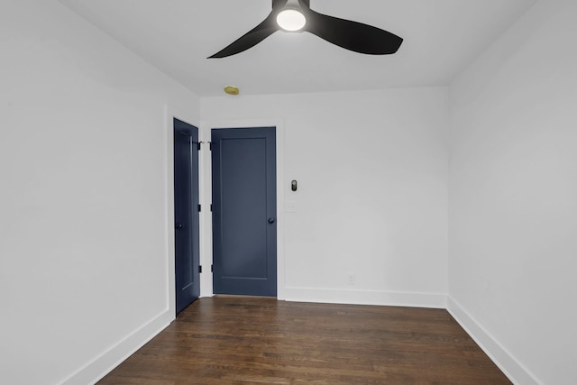 spare room featuring dark wood-type flooring, baseboards, and a ceiling fan