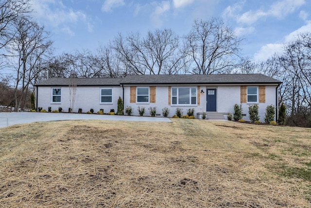 single story home featuring brick siding and a front lawn