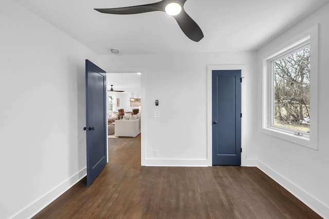 unfurnished bedroom featuring dark wood-style floors, a ceiling fan, and baseboards