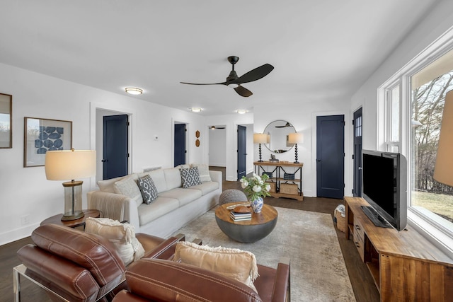 living room featuring dark wood-type flooring, ceiling fan, and baseboards