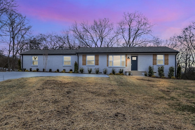 view of front of home with entry steps, a front lawn, and brick siding