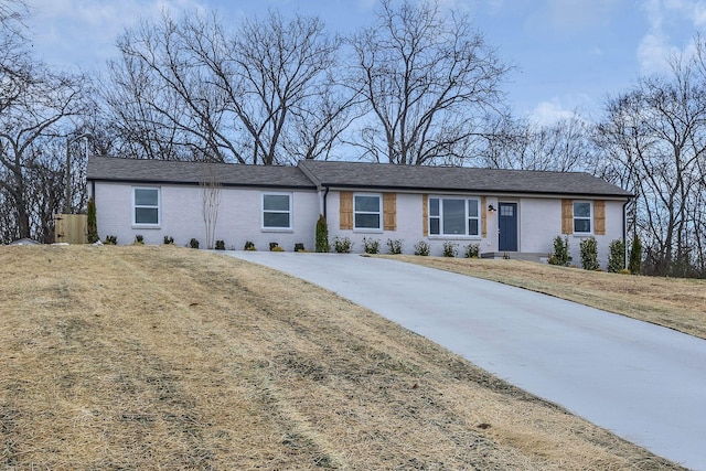 ranch-style house featuring brick siding and a front yard