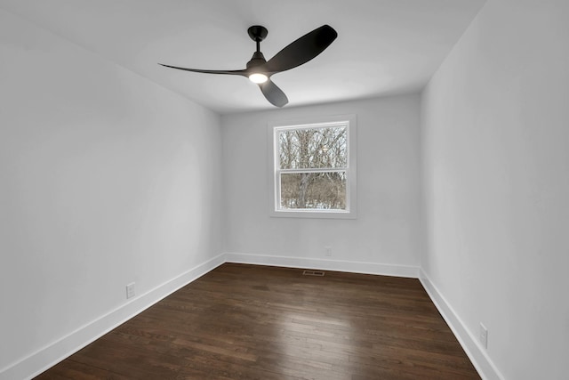 empty room with dark wood-style floors, baseboards, and a ceiling fan