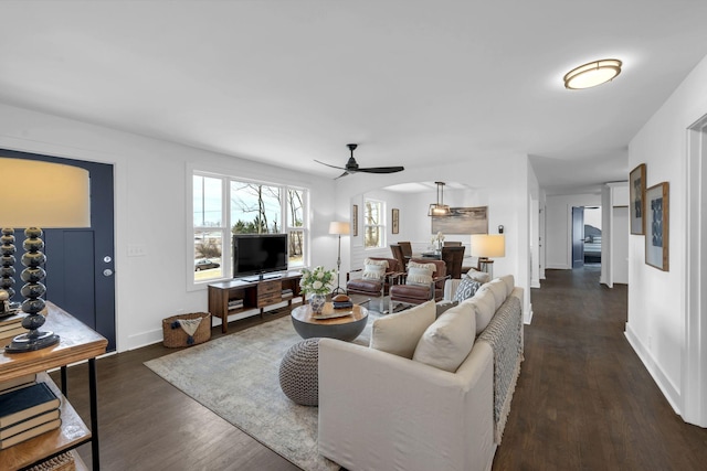 living room featuring dark wood-type flooring, ceiling fan, and baseboards