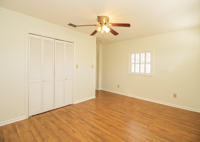 unfurnished bedroom featuring visible vents, baseboards, light wood-style flooring, ceiling fan, and a closet