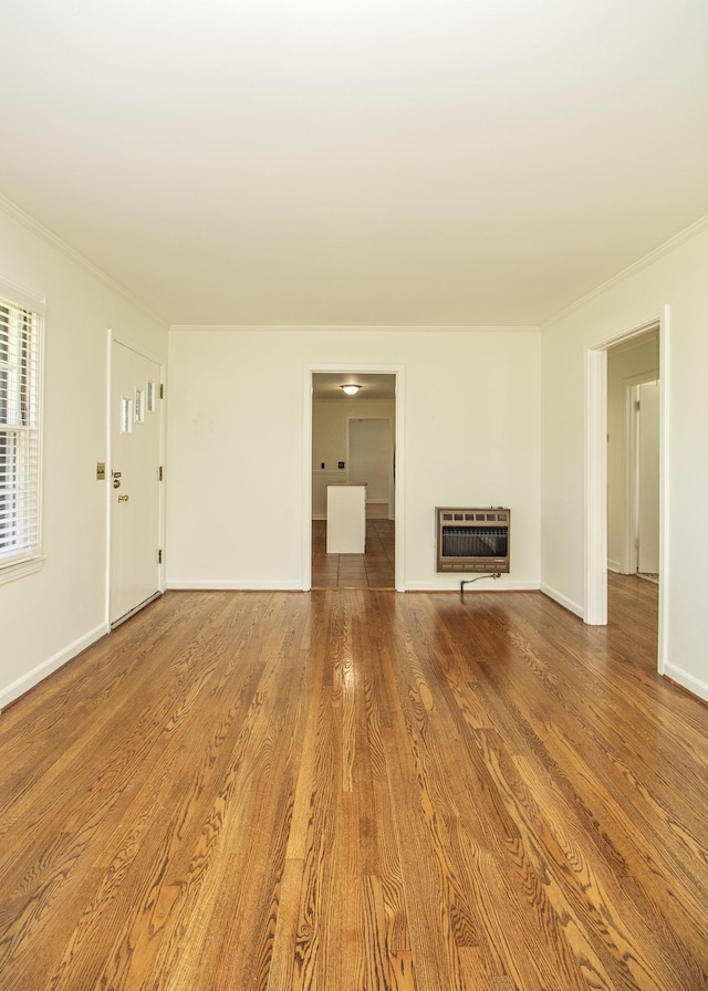 unfurnished living room featuring a fireplace, heating unit, ornamental molding, wood finished floors, and baseboards