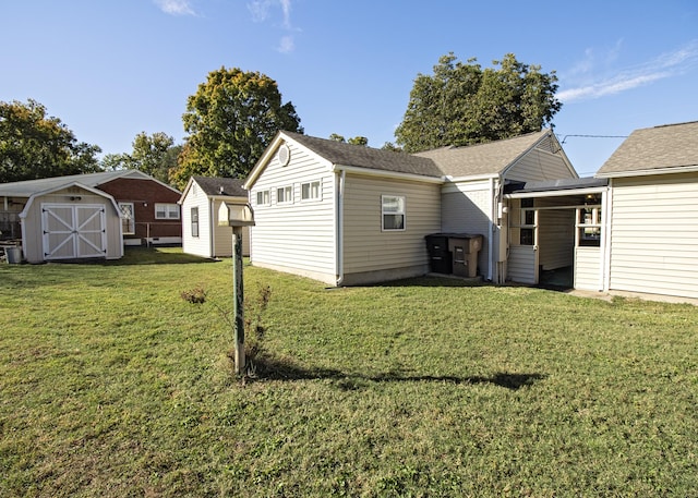 rear view of house with a storage shed, a lawn, and an outdoor structure