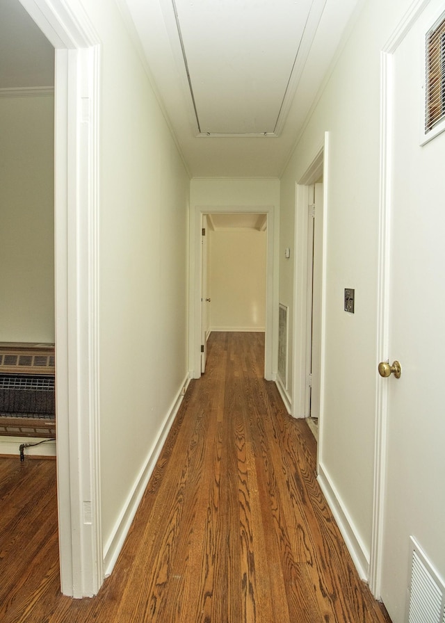 corridor with baseboards, attic access, visible vents, and wood finished floors