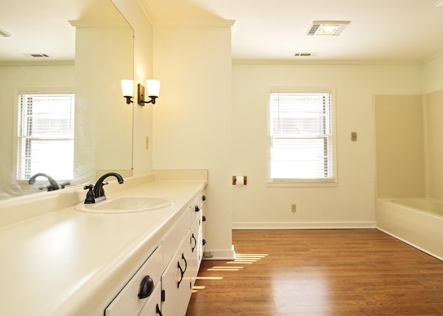 full bath with visible vents, ornamental molding, vanity, wood finished floors, and baseboards