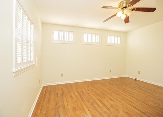 unfurnished room featuring a ceiling fan, a wealth of natural light, light wood-style flooring, and baseboards