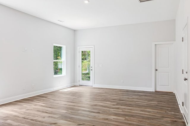 empty room with visible vents, baseboards, and wood finished floors