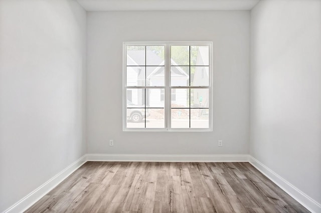 unfurnished room with light wood finished floors and baseboards