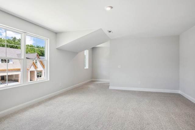 additional living space with baseboards, visible vents, and carpet flooring