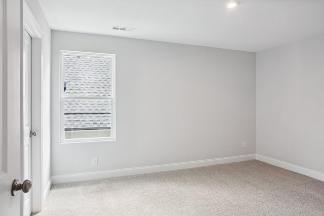 spare room with baseboards, plenty of natural light, visible vents, and light colored carpet