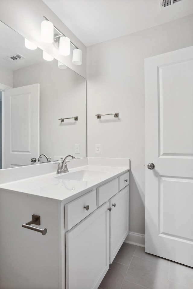 bathroom with visible vents, vanity, baseboards, and tile patterned floors