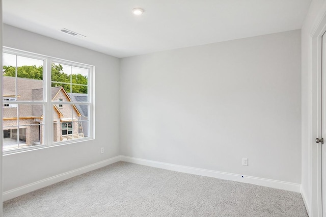 spare room featuring carpet flooring, visible vents, and baseboards