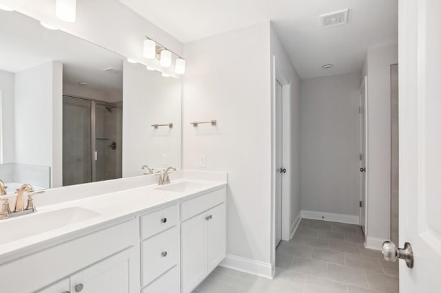 bathroom featuring double vanity, a stall shower, visible vents, and a sink