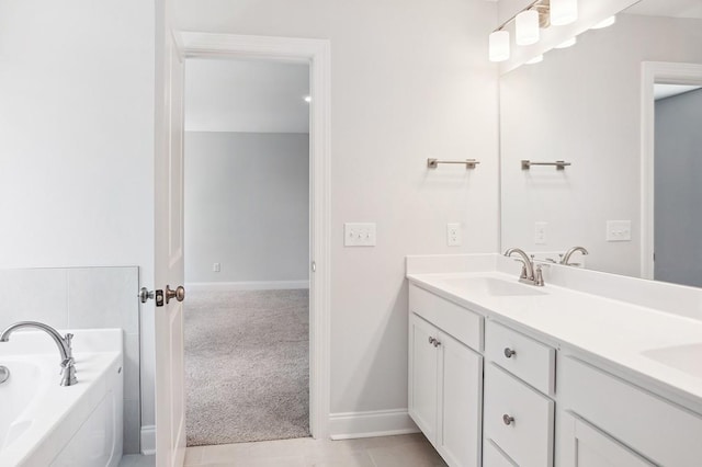 bathroom with double vanity, a sink, baseboards, and a bath