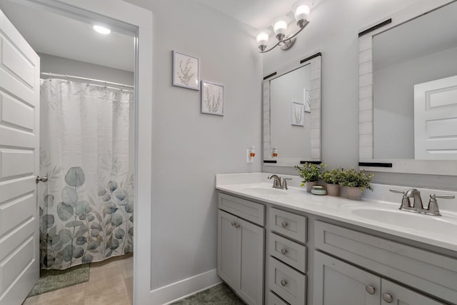 full bath featuring double vanity, baseboards, a sink, and a shower with shower curtain