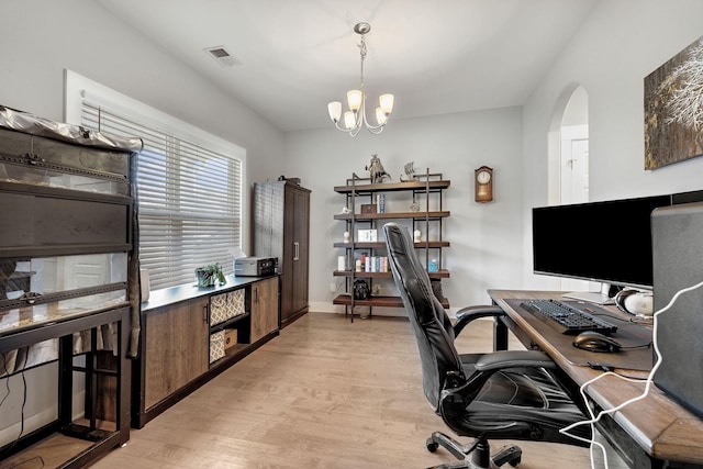 office space with a chandelier, arched walkways, visible vents, baseboards, and light wood finished floors