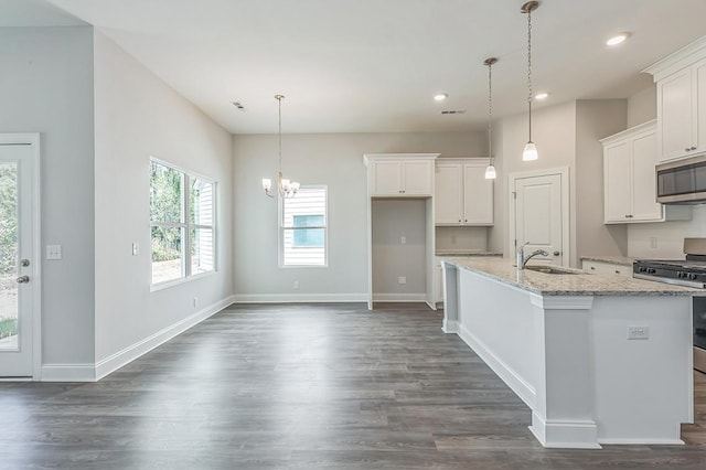 kitchen with an island with sink, white cabinetry, stainless steel appliances, and a sink