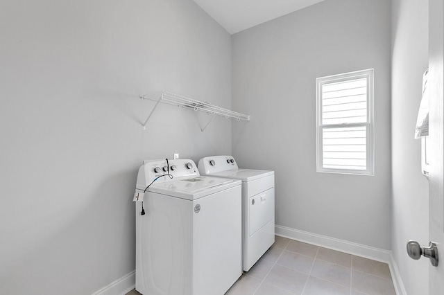 washroom featuring washer and dryer, laundry area, baseboards, and light tile patterned floors