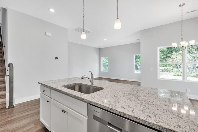 kitchen with visible vents, wood finished floors, light stone countertops, white cabinetry, and a sink