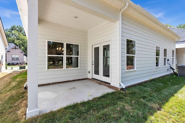 rear view of property with a patio area, central AC unit, and a lawn