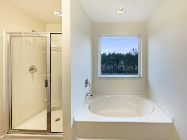 full bath featuring a garden tub and a shower stall