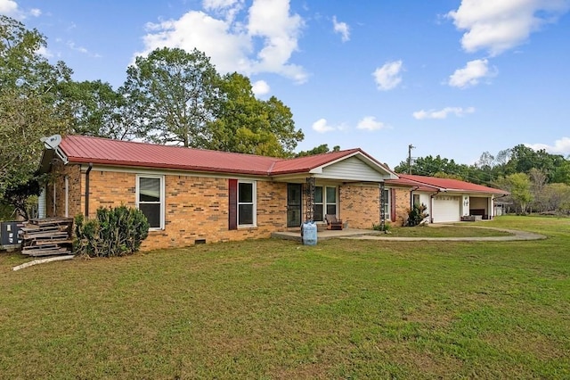 ranch-style home with a garage, metal roof, brick siding, and a front yard