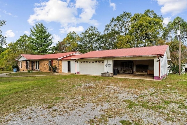 single story home featuring an attached garage, metal roof, driveway, and a front lawn