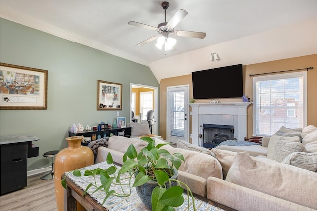 living room with vaulted ceiling, light wood finished floors, a fireplace, and a wealth of natural light