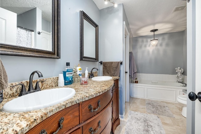 bathroom with visible vents, a sink, a textured ceiling, and a garden tub